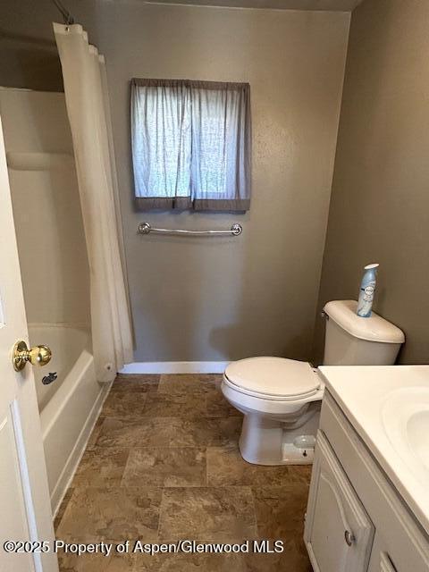 900 Breeze St, Craig, CO 81625 - full bath featuring toilet, baseboards, shower / bath combo with shower curtain, and vanity
