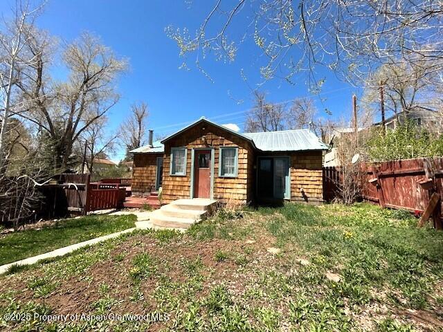 900 Breeze St, Craig, CO 81625 - view of front of house with a fenced backyard, metal roof, and a front yard