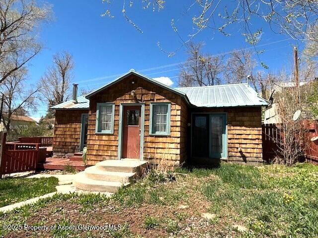900 Breeze St, Craig, CO 81625 - view of front of house with fence, a deck, and metal roof