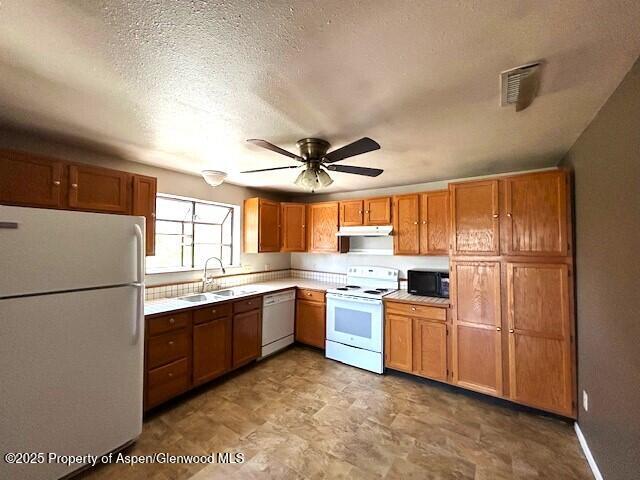 900 Breeze St, Craig, CO 81625 - kitchen featuring a ceiling fan, white appliances, light countertops, under cabinet range hood, and a sink