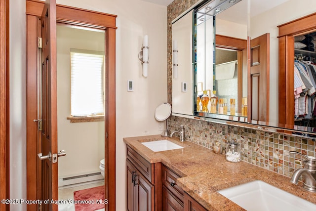 368 Meadow Ln, Glenwood Springs, CO 81601 - bathroom featuring a baseboard heating unit, tasteful backsplash, toilet, double vanity, and a walk in closet