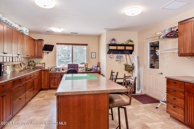 368 Meadow Ln, Glenwood Springs, CO 81601 - kitchen featuring light flooring, a kitchen bar, a kitchen island, light countertops, and brown cabinets