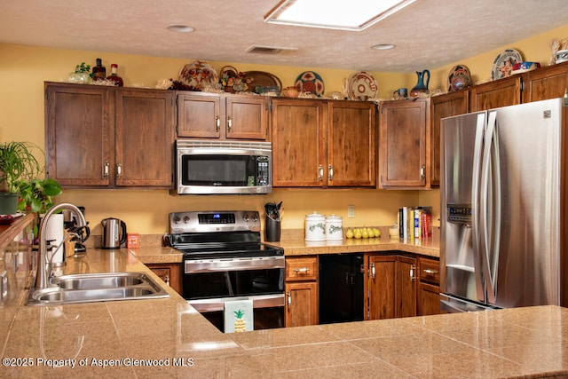 368 Meadow Ln, Glenwood Springs, CO 81601 - kitchen featuring stainless steel appliances, a sink, tile countertops, brown cabinets, and recessed lighting