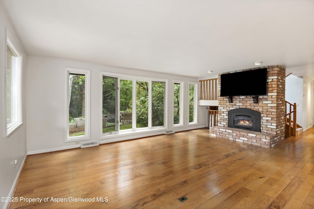 912 Red Mountain Dr, Glenwood Springs, CO 81601 - unfurnished living room with hardwood / wood-style flooring, healthy amount of natural light, and a fireplace