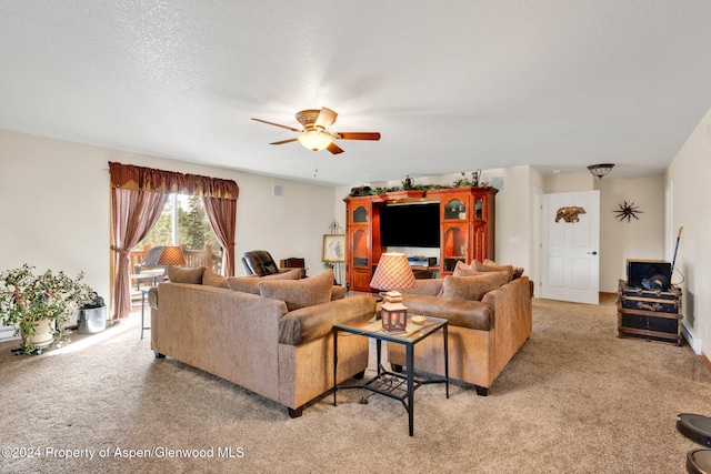 carpeted living room with ceiling fan and a textured ceiling