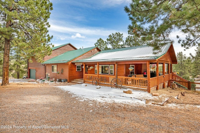 log cabin featuring covered porch