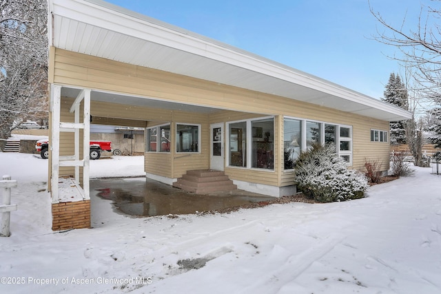 view of snow covered back of property