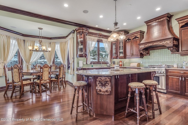 81 River Park Ln, Carbondale, CO 81623 - kitchen with high end range, custom range hood, light stone countertops, a chandelier, and a breakfast bar