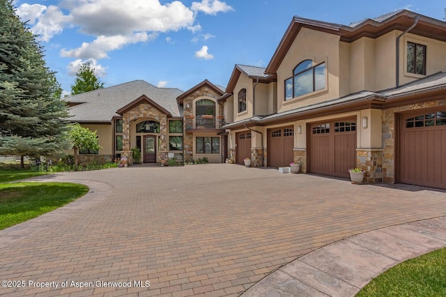 81 River Park Ln, Carbondale, CO 81623 - view of front of home with stone siding, an attached garage, driveway, and stucco siding