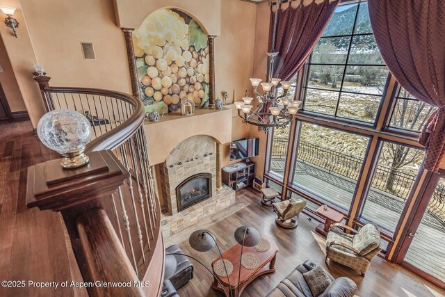 81 River Park Ln, Carbondale, CO 81623 - living room with wood finished floors, a towering ceiling, a chandelier, and a fireplace