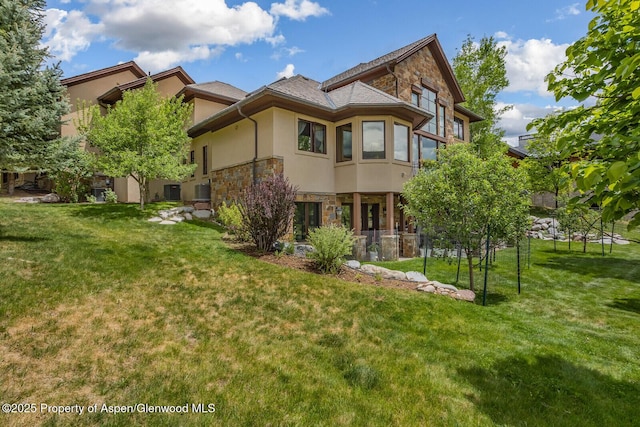 81 River Park Ln, Carbondale, CO 81623 - rear view of property featuring stone siding, stucco siding, and a yard