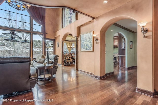 81 River Park Ln, Carbondale, CO 81623 - living room featuring a chandelier, hardwood / wood-style floors, baseboards, ornamental molding, and arched walkways