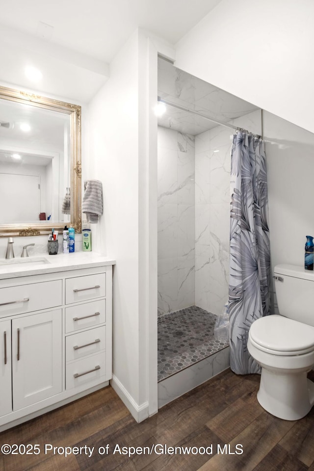 full bathroom with toilet, curtained shower, wood finished floors, and vanity