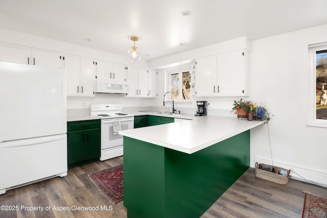 kitchen featuring white appliances, dark wood finished floors, a peninsula, light countertops, and white cabinetry