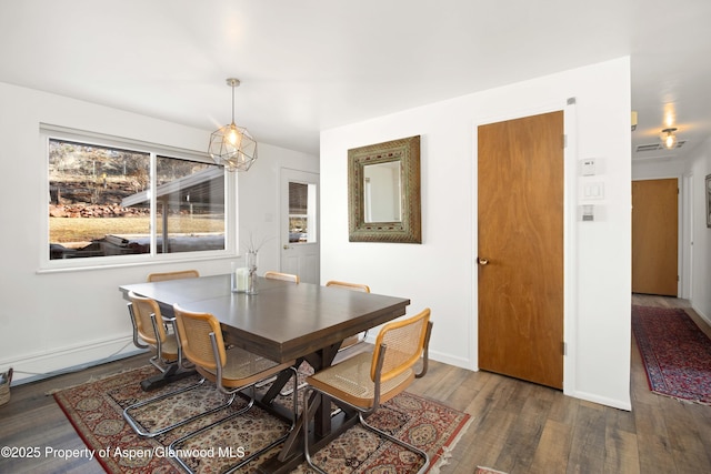 dining space with baseboards and wood finished floors