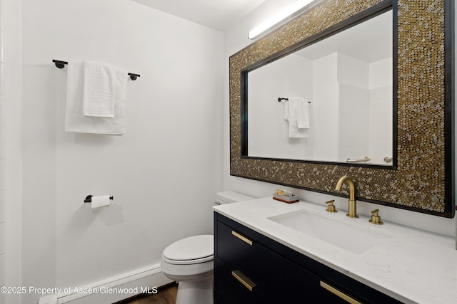 bathroom featuring toilet, a baseboard heating unit, wood finished floors, vanity, and baseboards