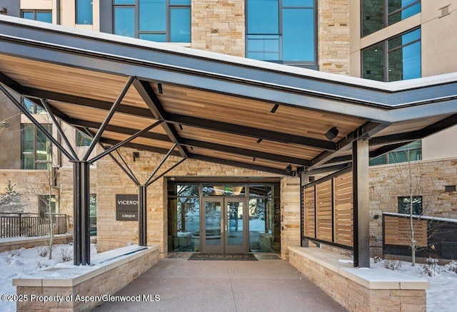 130 Wood Rd Unit 264, Snowmass Village, CO 81615 - snow covered property entrance featuring stone siding and french doors