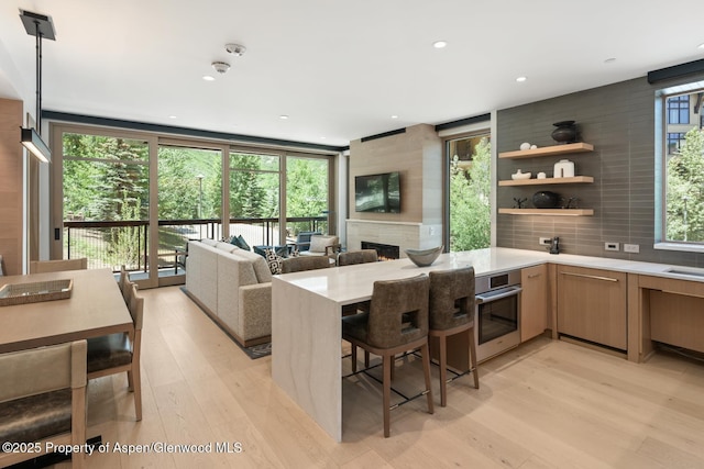130 Wood Rd Unit 264, Snowmass Village, CO 81615 - kitchen featuring oven, light countertops, light wood finished floors, a peninsula, and healthy amount of natural light