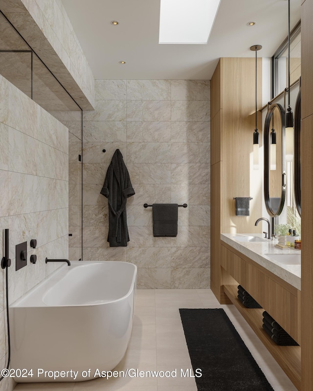 221 Wood Rd Unit 718, Snowmass Village, CO 81615 - bathroom featuring tile walls, a freestanding bath, double vanity, tile patterned flooring, and a skylight