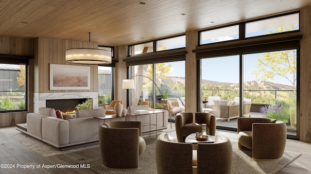 221 Wood Rd Unit 718, Snowmass Village, CO 81615 - living room featuring wood ceiling, light wood-style floors, a mountain view, wooden walls, and a high end fireplace