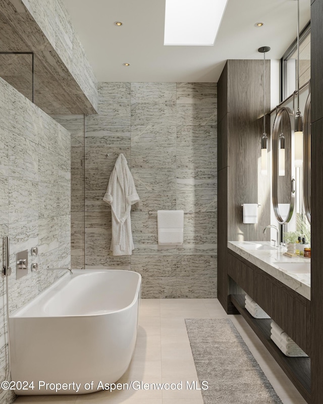 221 Wood Rd Unit 718, Snowmass Village, CO 81615 - full bathroom featuring tile walls, a freestanding bath, double vanity, tile patterned flooring, and plenty of natural light