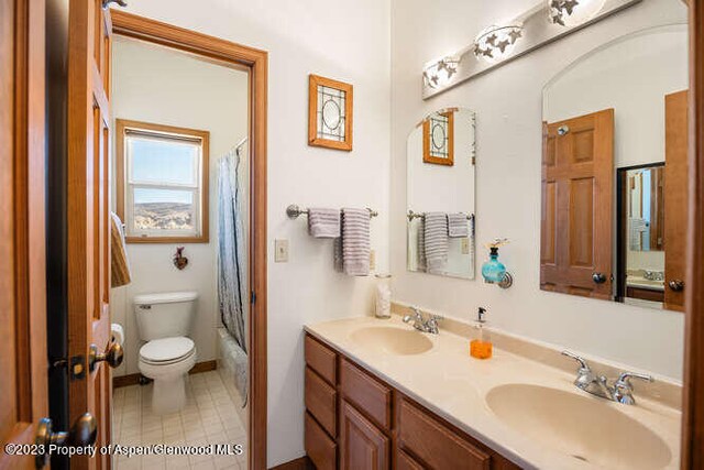 full bathroom featuring vanity, shower / bath combo, and toilet