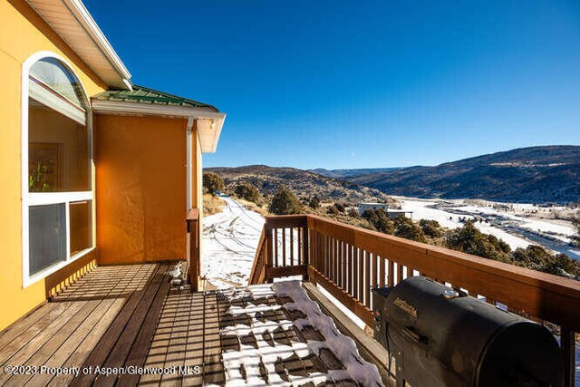 snow covered deck with a mountain view