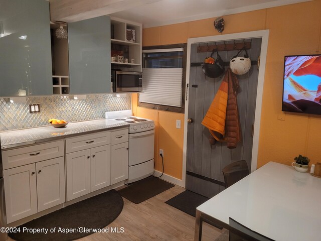 11101 County Road 117 Unit B4, Glenwood Springs, CO 81601 - kitchen featuring white electric range oven, stainless steel microwave, light wood finished floors, open shelves, and tasteful backsplash
