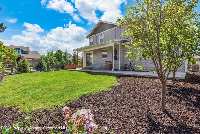510 S Wildhorse Dr, New Castle, CO 81647 - back of property featuring a patio, a lawn, and board and batten siding