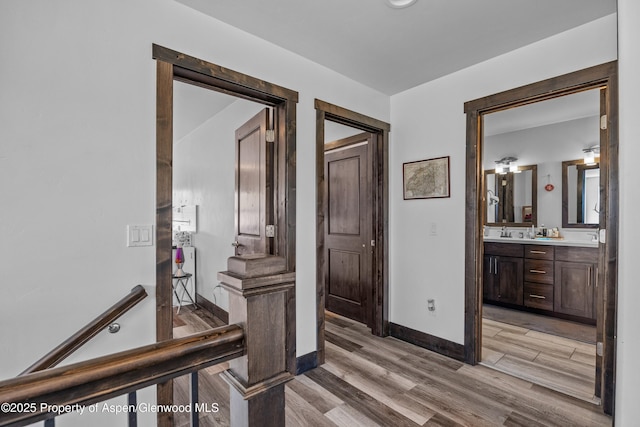 510 S Wildhorse Dr, New Castle, CO 81647 - hallway featuring light wood-type flooring, baseboards, and a sink
