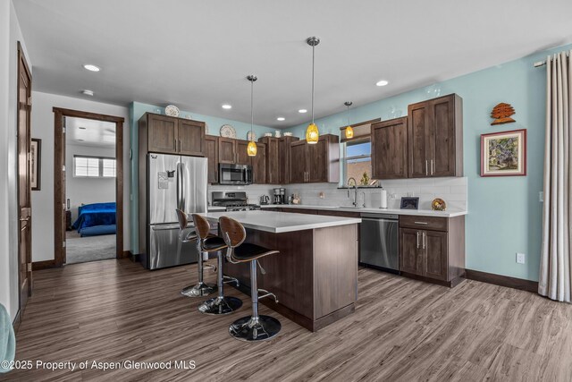 510 S Wildhorse Dr, New Castle, CO 81647 - kitchen with appliances with stainless steel finishes, dark brown cabinetry, a center island, wood finished floors, and recessed lighting