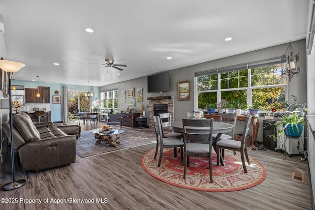 510 S Wildhorse Dr, New Castle, CO 81647 - dining room with ceiling fan, wood finished floors, a stone fireplace, recessed lighting, and healthy amount of natural light