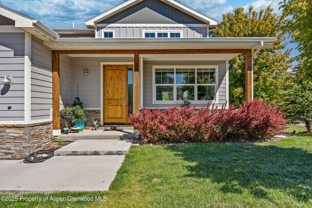 510 S Wildhorse Dr, New Castle, CO 81647 - entrance to property featuring a porch, a lawn, board and batten siding, and stone siding