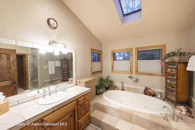 bathroom featuring vaulted ceiling with skylight, vanity, and separate shower and tub