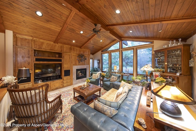 tiled living room with ceiling fan, beam ceiling, high vaulted ceiling, wooden ceiling, and a tiled fireplace