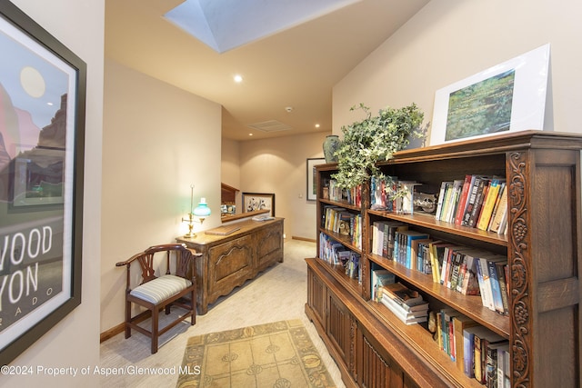 hall with a skylight and light carpet