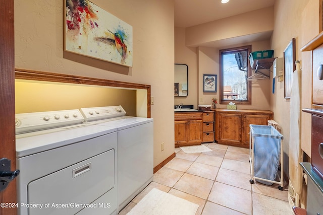 laundry room featuring independent washer and dryer, sink, and light tile patterned floors