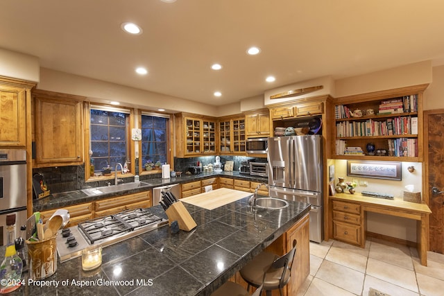 kitchen featuring a kitchen breakfast bar, decorative backsplash, sink, and stainless steel appliances