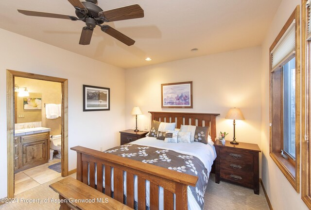 bedroom with ensuite bath, ceiling fan, and light tile patterned flooring