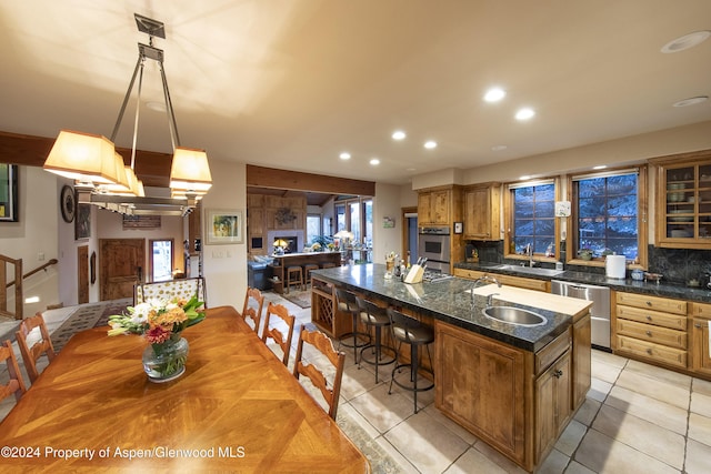 kitchen with pendant lighting, decorative backsplash, a center island, and stainless steel dishwasher