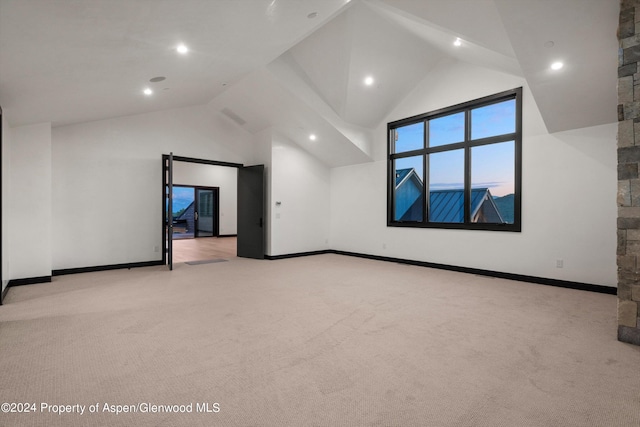 bonus room with light colored carpet and high vaulted ceiling