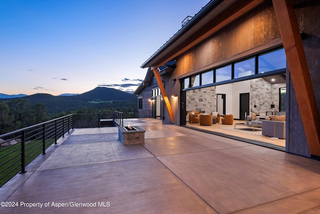 patio terrace at dusk featuring a mountain view