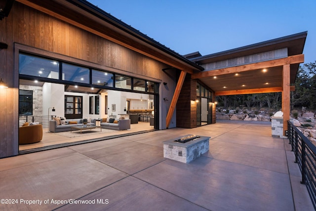 patio terrace at dusk featuring an outdoor living space with a fire pit