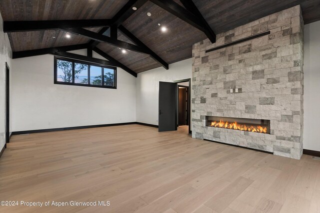 unfurnished living room featuring a fireplace, wooden ceiling, beamed ceiling, and light hardwood / wood-style floors