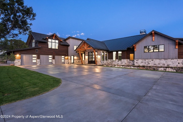 modern inspired farmhouse with a lawn and a garage