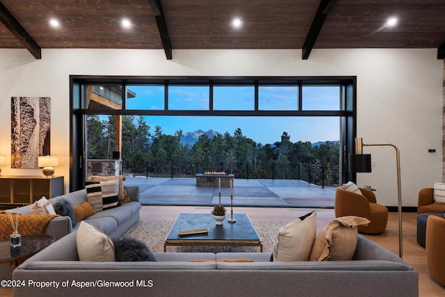 living room featuring beam ceiling, wood-type flooring, and wood ceiling