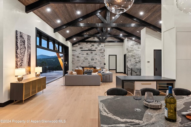 living room with a mountain view, light wood-type flooring, high vaulted ceiling, and a fireplace