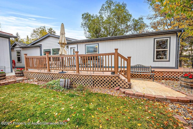 back of property with a yard and a wooden deck