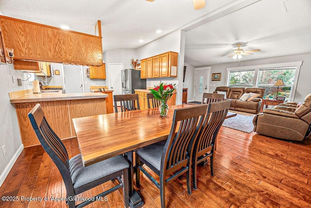 dining area featuring ceiling fan and dark wood-type flooring