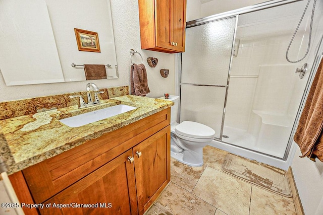 bathroom with an enclosed shower, vanity, and toilet